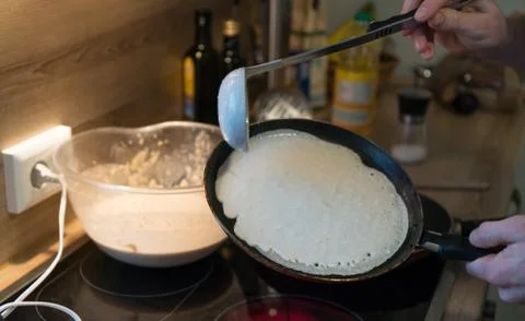 Prepares pancakes in the kitchen Stock Photos