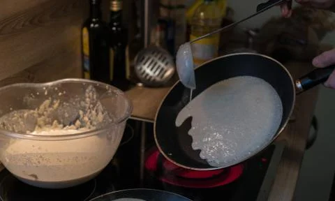 Prepares pancakes in the kitchen Stock Photos