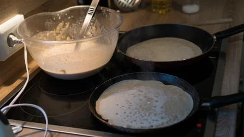 Prepares pancakes in the kitchen Stock Photos