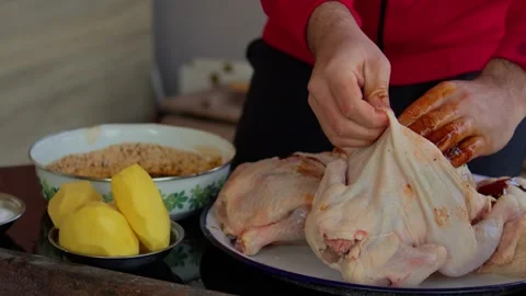 Preparing and cooking chicken in a traditional outdoor oven. Stock Footage 310017363