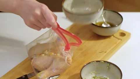 Preparing and marinating raw chicken meat, packing in plastic bag. Cooking food Stock Footage 256456929