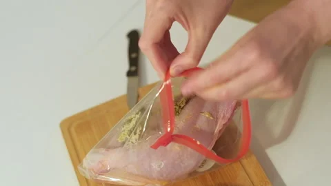Preparing and marinating raw chicken meat, packing in plastic bag. Cooking food Stock Footage 256457628