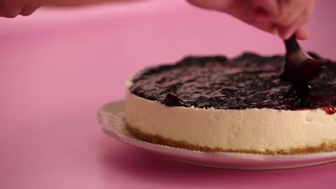 Preparing and serving a cheesecake with berry toppings Stock Footage 133807765