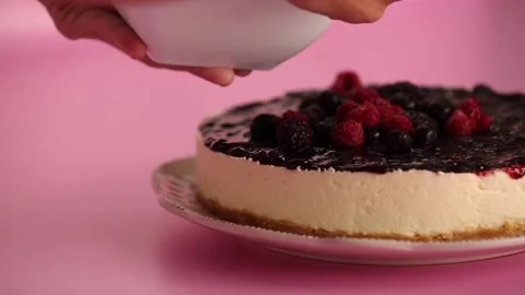 Preparing and serving a cheesecake with berry toppings Stock Footage 133808050