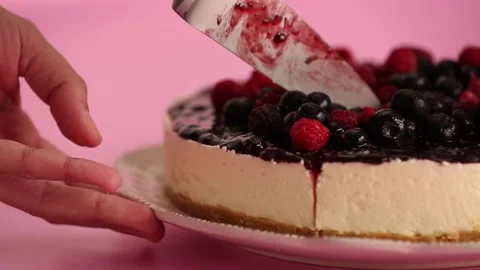Preparing and serving a cheesecake with berry toppings Stock Footage 133808082
