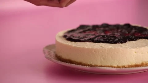 Preparing and serving a cheesecake with berry toppings Stock Footage 133808117