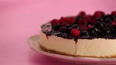 Preparing and serving a cheesecake with berry toppings Stock Footage 133808348