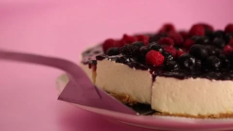 Preparing and serving a cheesecake with berry toppings Stock Footage 133808350