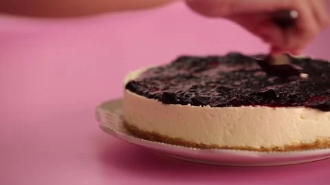 Preparing and serving a cheesecake with berry toppings Stock Footage 133808351