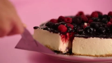 Preparing and serving a cheesecake with berry toppings Stock Footage 133808457