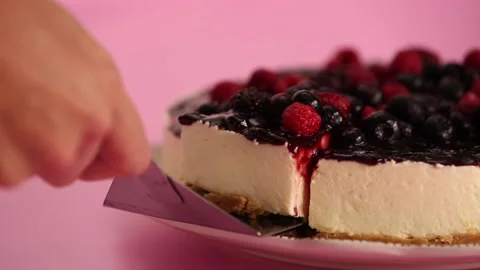 Preparing and serving a cheesecake with berry toppings Stock Footage 133808655