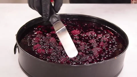 Preparing and serving a cheesecake with berry toppings Stock Footage 141699631
