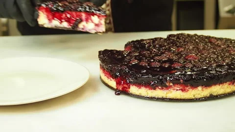 Preparing and serving a cheesecake with berry toppings. Stock Footage 141700223