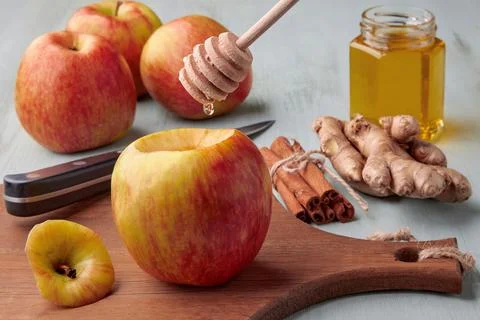 Preparing apples for baking in the oven. A drop of honey flows from a spoon o Stock Photos