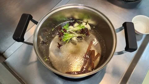 Preparing Aromatic Asian Broth with Star Anise Cinnamon and Scallions Stock Photos
