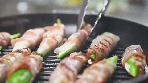 Preparing of bacon wrapped stuffed green chillies on a grill pan. Stock Footage 150830209