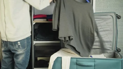 Preparing bag for travel. Overhead view of woman packing things in a suitcase at Stock Footage 336237512