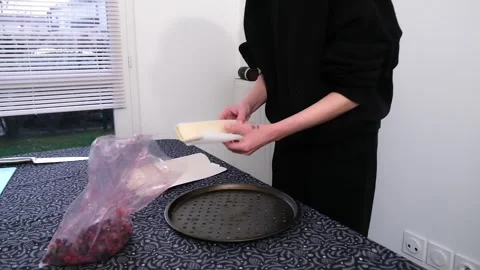 Preparing bakeware: unwrapping and arranging parchment paper for cooking Stock Footage 307447711