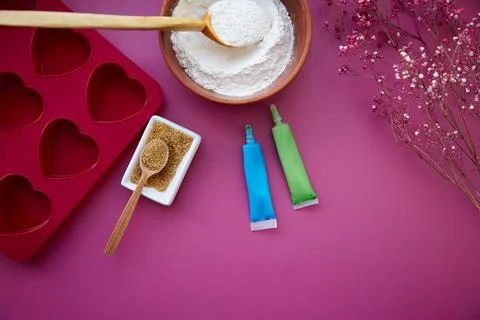 Preparing for baking: heart-shaped silicone mold, cane sugar, glaze, flour Stock Photos