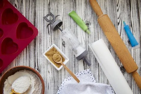 Preparing for baking with kitchenware: heart-shaped silicone mold, rolling pin Stock Photos