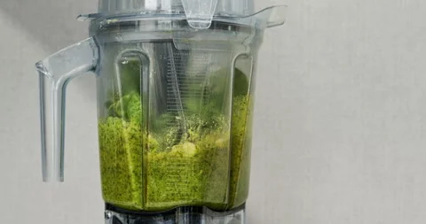 Preparing basil pesto with Parmesan and macadamia nuts with blender. Stock Footage 283727286