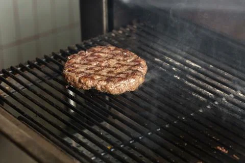 Preparing a batch of ground beef patties or frikadeller on grill or BBQ. Cook Stock Photos