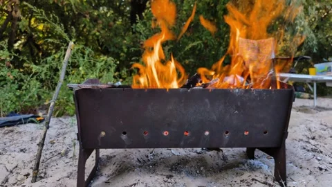 Preparing for a Beach BBQ: Fire Burning in a Metal Grill Stock Footage 286096567