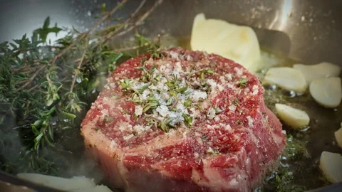 Preparing beef in skillet, capture of seared meat infused with herbs and spices Stock Footage 324574801