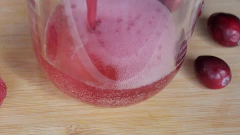 Preparing a Berry Milkshake: Cranberries and Glass on Wooden Surface Stock Footage 334581875