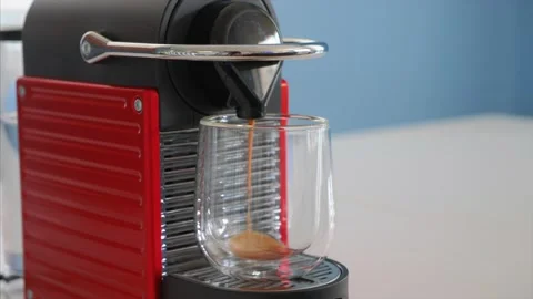 Preparing big glass capsule coffee in red nespresso coffee machine Stock-Footage 131091542