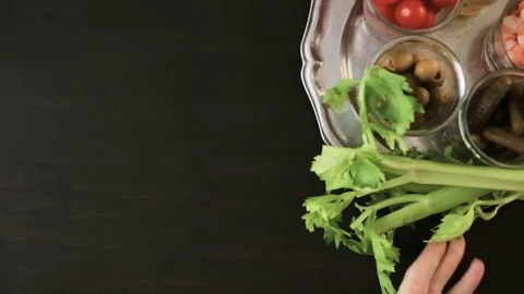Preparing bloody mary cocktail garnished with celery sticks, olives, and bacon s Stock Footage