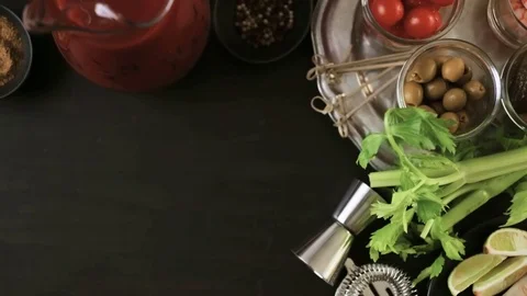Preparing bloody mary cocktail garnished with celery sticks, olives, and bacon s Stock Footage