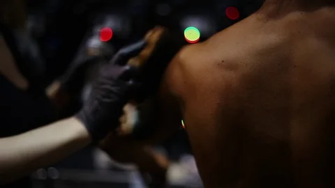 Preparing for bodybuilding competitions. Hands spreading tan cream using a Video stock 75368763