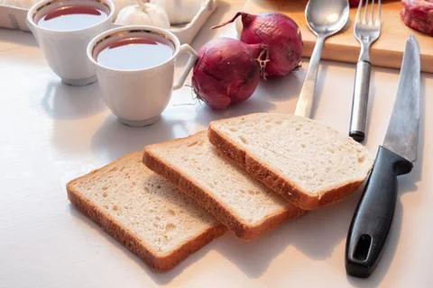 Preparing Bread with tea cup and kitchenware, egetable and meat on table Stock Photos