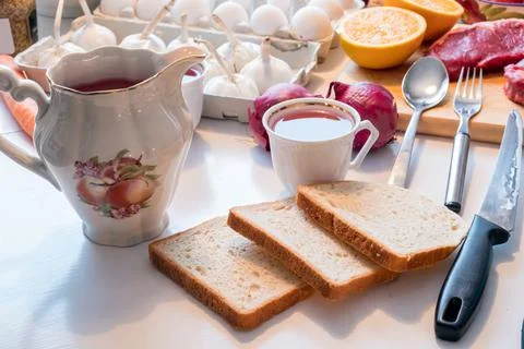 Preparing Bread with tea cup and kitchenware, egetable and meat on table Stock Photos