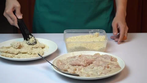 Preparing Breaded Chicken Breast for Frying on Kitchen Table Stock Footage 334324408