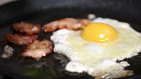 Preparing breakfast. frying bacon close-up slow mo Stock Footage 166528585