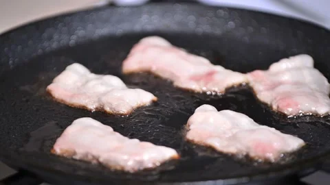 Preparing breakfast. frying bacon in a pan close-up Stock Footage 184051876