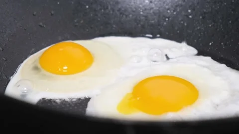 Preparing breakfast. Frying an egg in a pan. Cooking. Healthy food Stock Footage 253066398