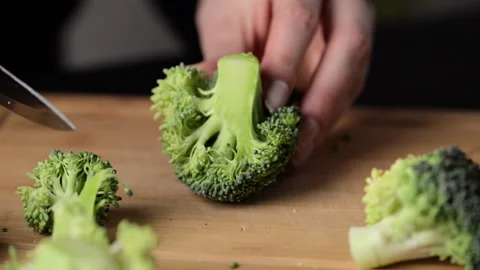 Preparing broccoli for cooking. Cutting broccoli cabbage on a cutting board. Stock Footage 273795525