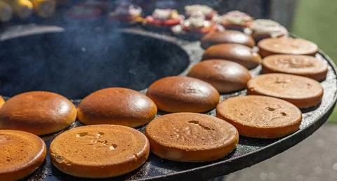 Preparing burger buns. The buns are arranged in a circle on a hot flat-top gr Stock Photos