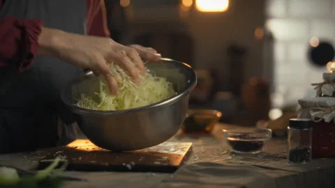 Preparing cabbage for fermentation in a cozy kitchen at sunset 스톡 동영상 331356362