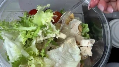 Preparing Caesar salad in a plastic container with all the ingredients on the Stock Footage 323471543