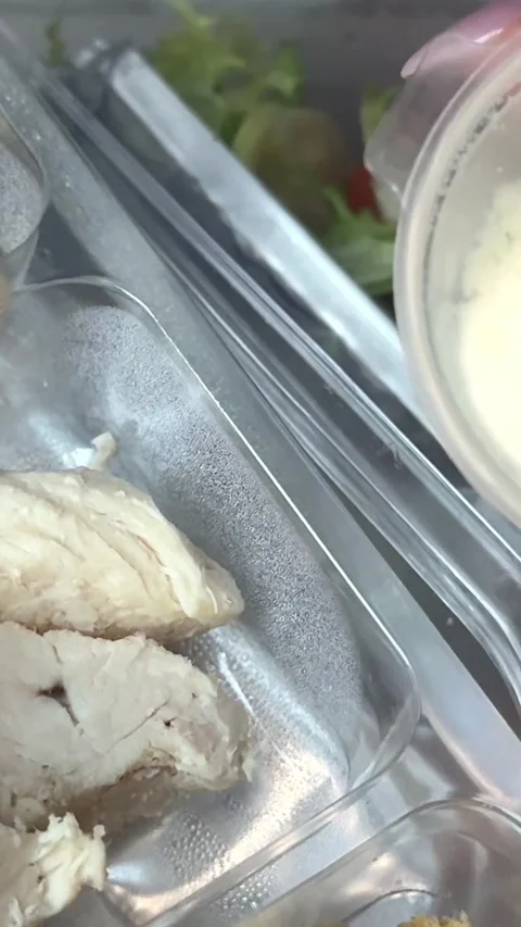 Preparing Caesar salad in a plastic container with all the ingredients on the Stock Footage 323471775