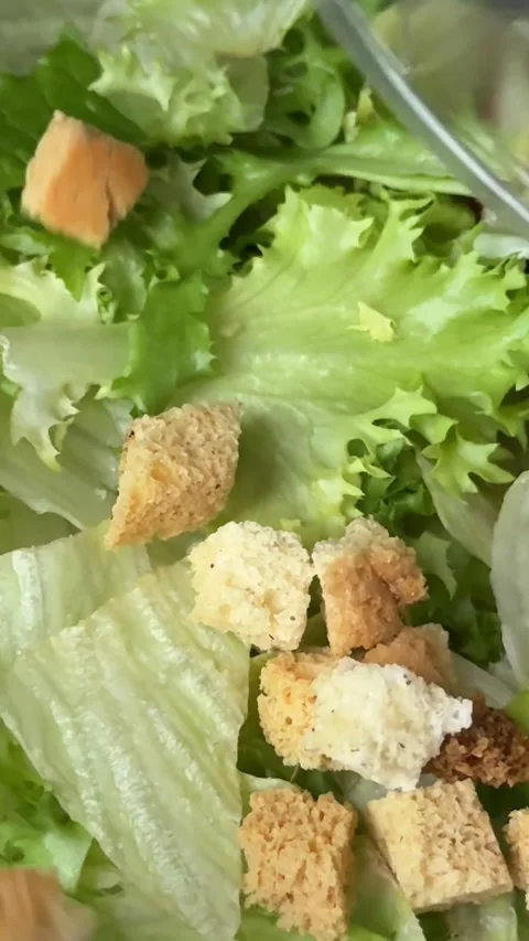 Preparing Caesar salad in a plastic container with all the ingredients on the Stock Footage 323472249