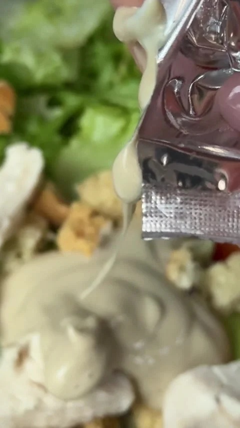 Preparing Caesar salad in a plastic container with all the ingredients on the Stock Footage 323472338