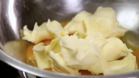 Preparing cake. Close-up shot of egg yolks and butter in a bowl. 4K Stockbeeldmateriaal 136490329