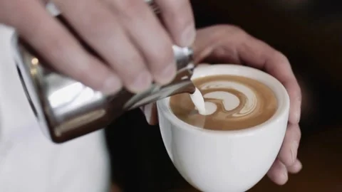 Preparing Cappuccino Coffee. Milk being poured into a mug with coffee. Vídeo Stock 334648124