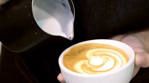Preparing Cappuccino Coffee. Milk being poured into a mug with coffee. Stock-Footage 334648182