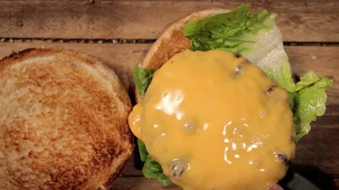 Preparing a cheeseburger in slow motion - top down view Stock Footage 151125904